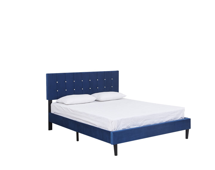 side view of a white mattress and pillows on a royal blue velvet upholstered bed base with a headboard decorated with faux diamond buttons